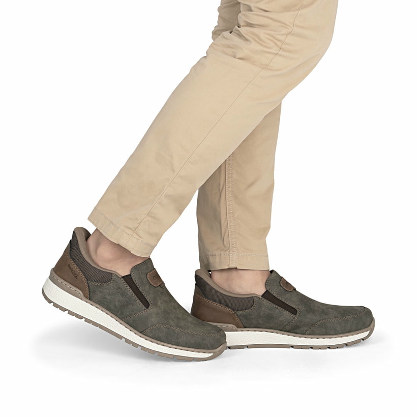Braungraue Rieker Herren Slipper B9057-25 mit einem Gummizug sowie Extraweite H. Schuh am Fuß.