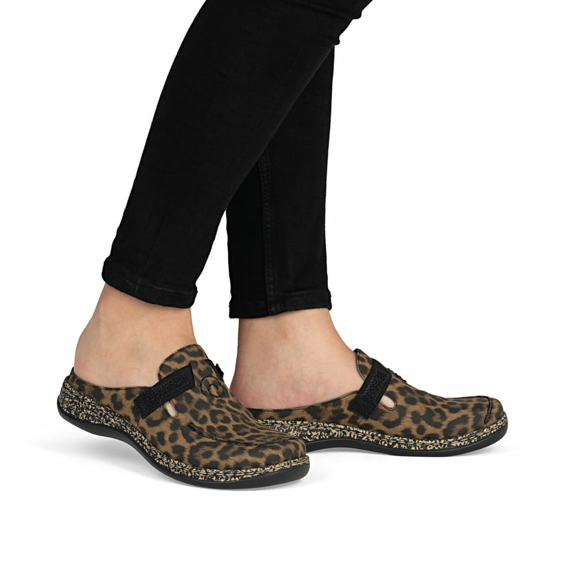 Braune Rieker Damen Clogs 46393-90 mit Leo-Print sowie extra weicher Decksohle. Schuh am Fuß.