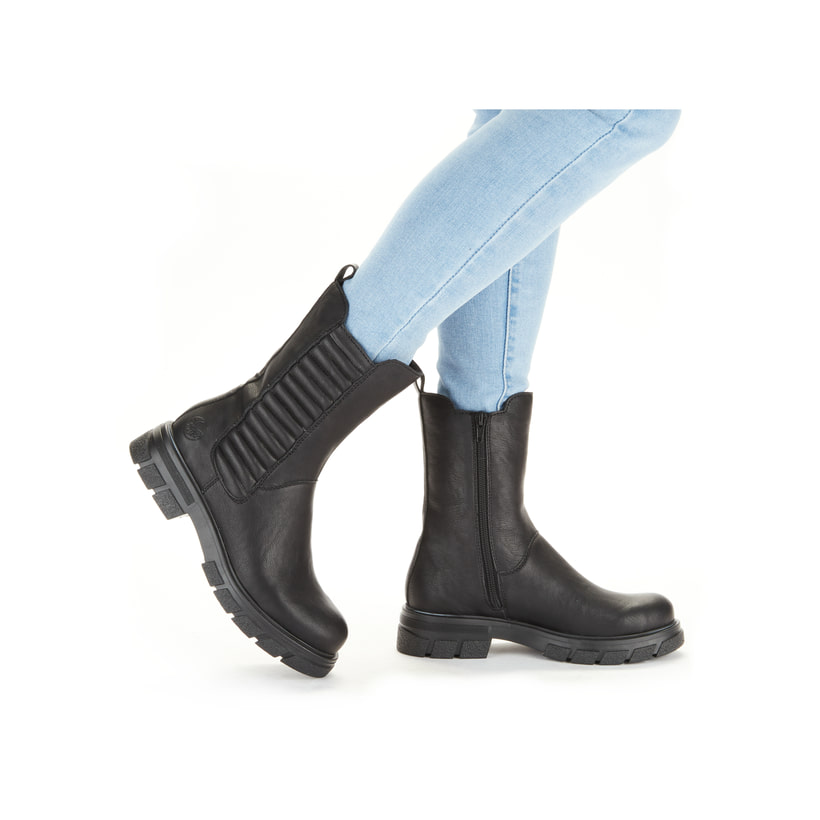 Tiefschwarze Rieker Damen Chelsea Boots Z9181-00 mit einer robusten Profilsohle. Schuh seitlich schräg