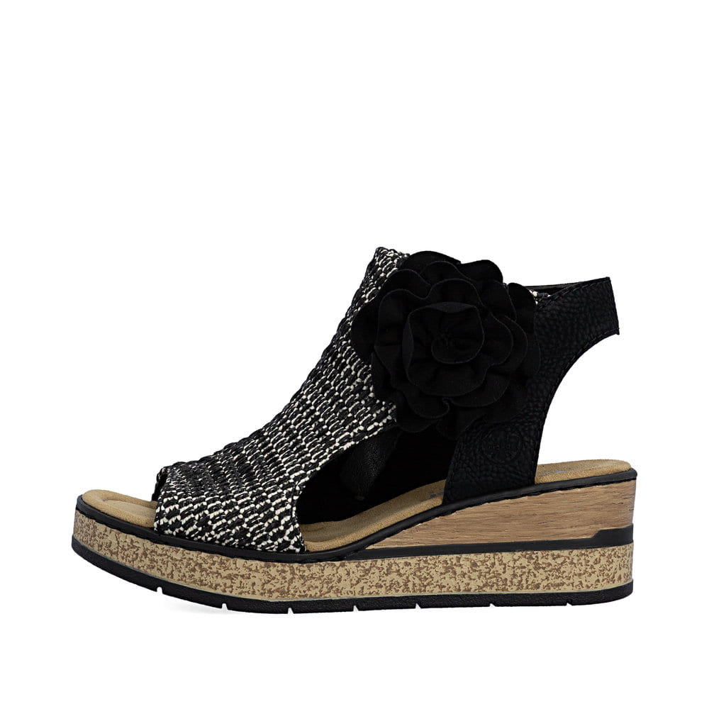 Schwarze Rieker Keilsandaletten 63791-01 mit dekorativer Blume. Schuh Außenseite.