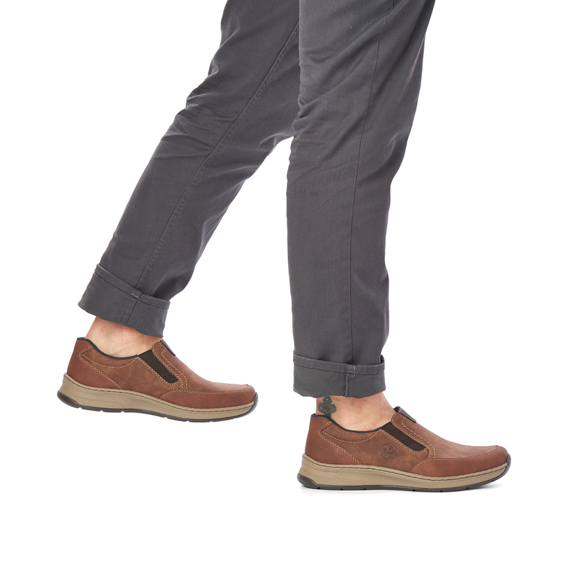 
Holzbraune Rieker Herren Slipper 14362-24 mit einer schockabsorbierenden Sohle. Schuh am Fuß