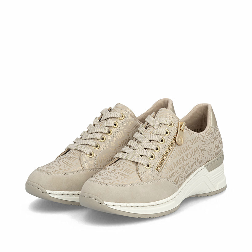 Baskets basses Rieker beiges pour femme N4316-62 avec finition métallisée. Chaussures inclinées sur le côté.