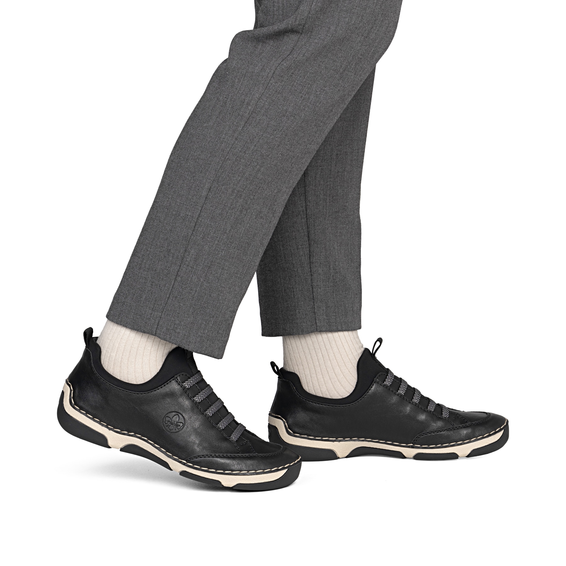 Schwarze Rieker Damen Slipper 55952-00 mit einem Gummizug. Schuh am Fuß.