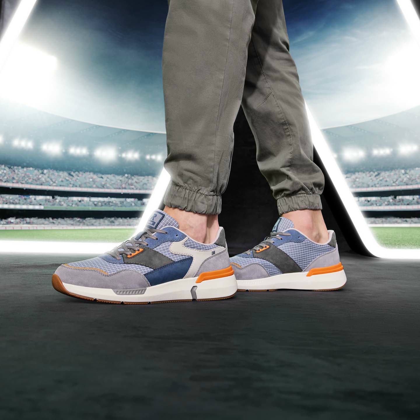 Blaue Rieker Herren Sneaker Low U1402-10 mit Schnürung sowie flexibler Sohle. Schuh am Model.