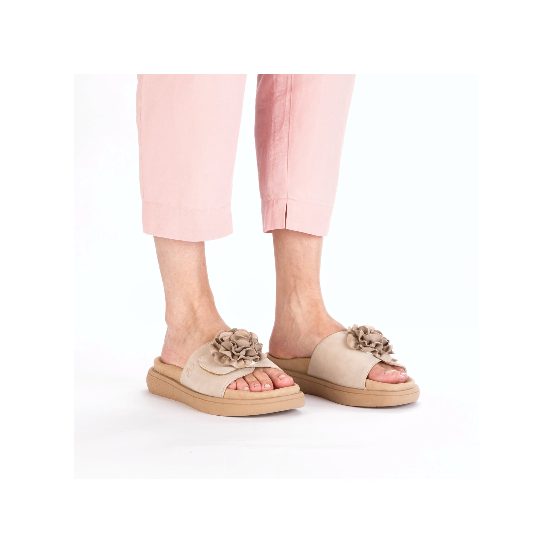 Beige Rieker Damen Pantoletten V1562-62 mit dekorativer Blume. Schuh am Fuß.
