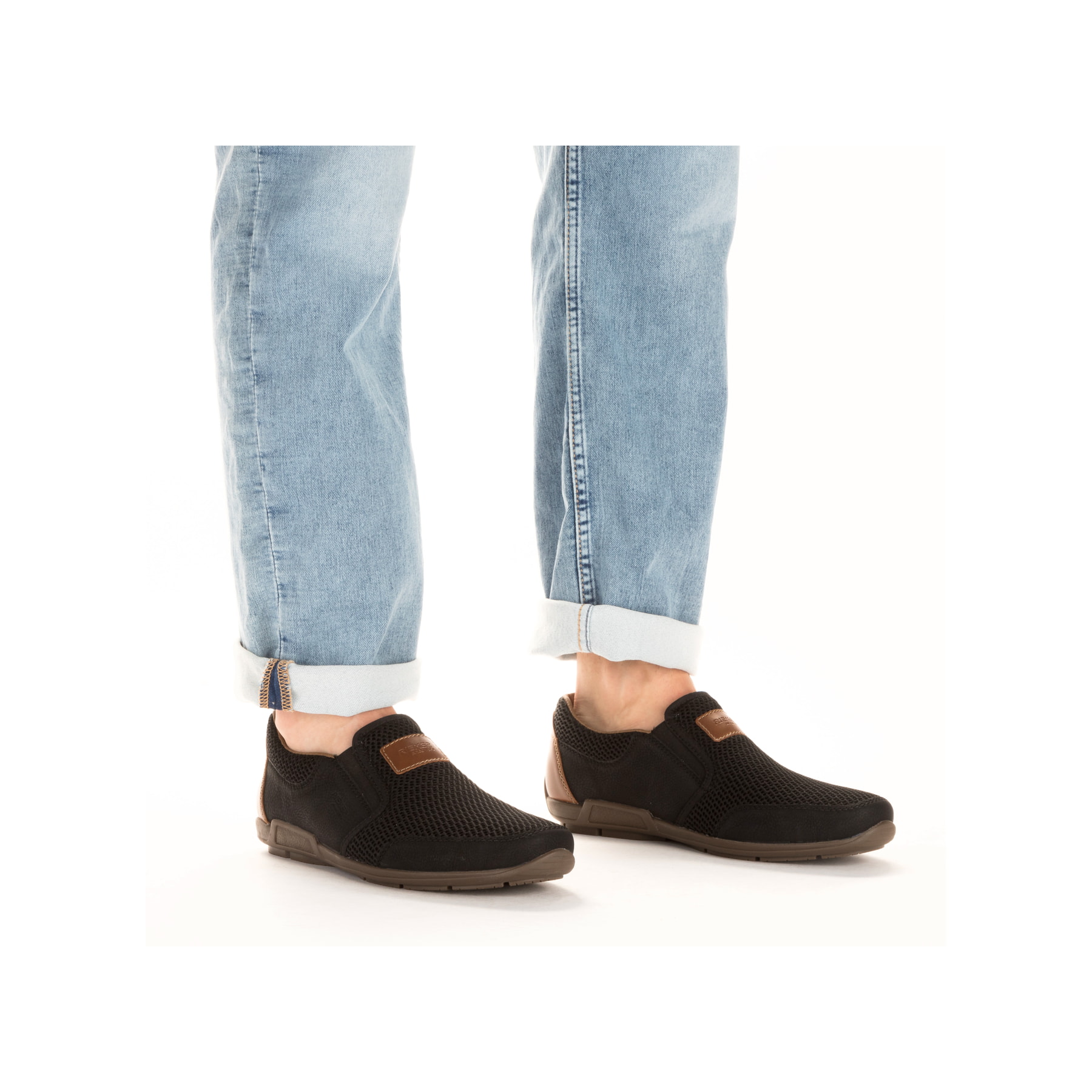 Schwarze Rieker Herren Slipper 09069-00 mit Gummizug sowie Komfortweite G 1/2. Schuh am Fuß.