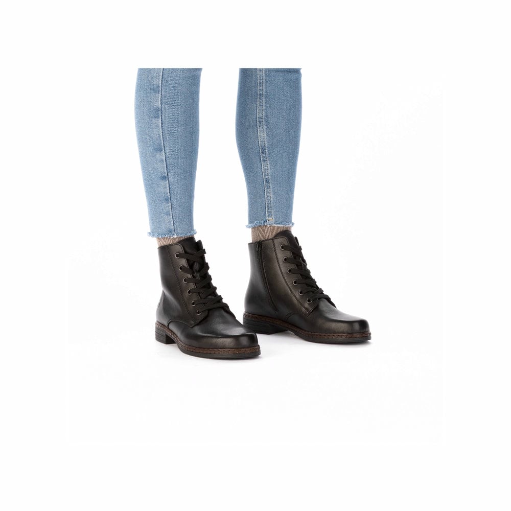 Nachtschwarze Rieker Damen Schnürstiefel 75130-00 mit einer schockabsorbierenden Sohle. Schuh am Fuß