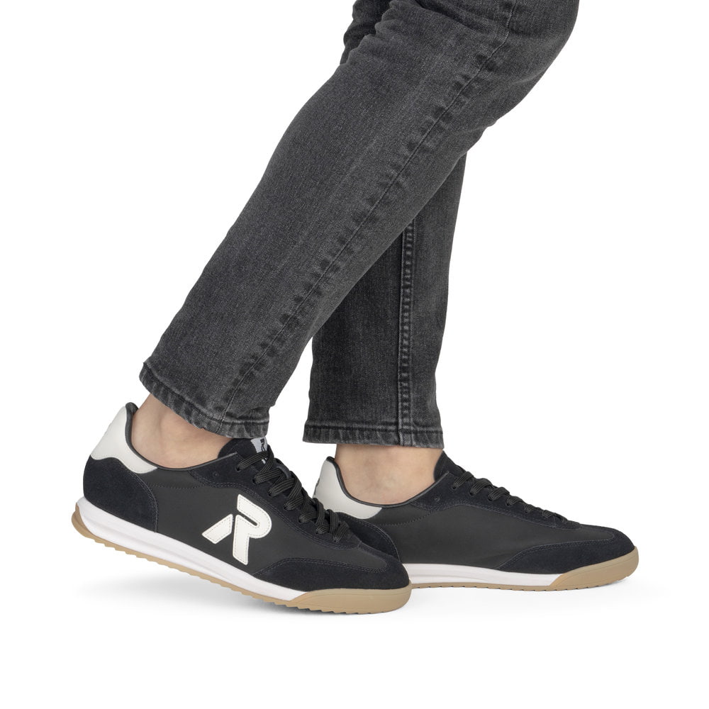 Schwarze Rieker Herren Sneaker Low U4000-00 mit Schnürung sowie abgesetztem Logo. Schuh am Fuß.