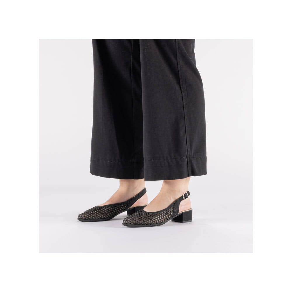 Schwarze Rieker Slingpumps 47060-01 mit eleganten Zierlochungen sowie Schnallen. Schuh am Fuß.