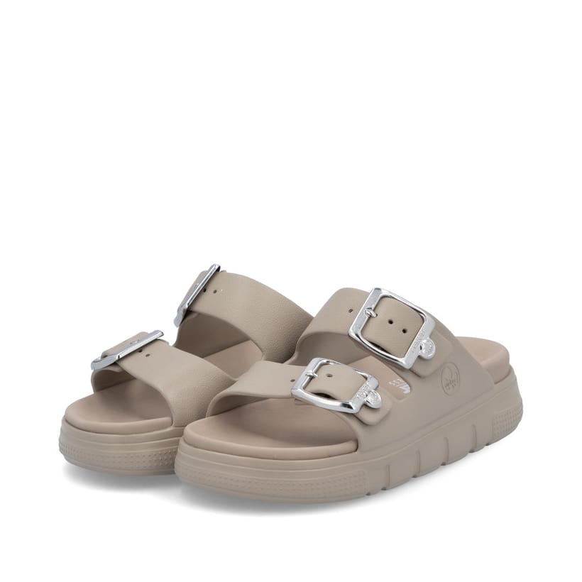 Beige Rieker Damen Pantoletten P2180-60 mit Schnallen sowie ultraleichter Sohle. Schuhpaar seitlich schräg.
