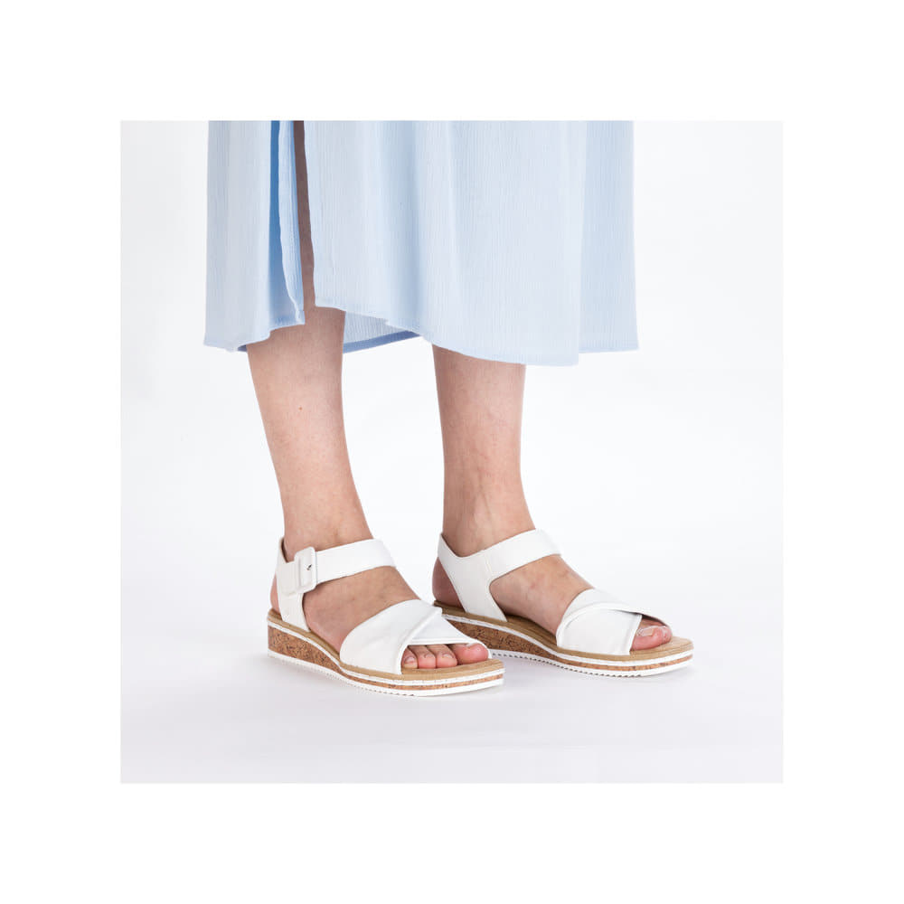 Weiße Rieker Keilsandaletten V3691-80 mit trendiger Schnalle. Schuh am Fuß.