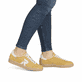 Gelbweiße Rieker Damen Sneaker Low W2200-68 mit einer Schnürung. Schuh am Fuß.