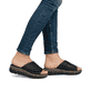 Schwarze Rieker Damen Pantoletten V2351-00 mit floralem Muster. Schuh am Fuß.