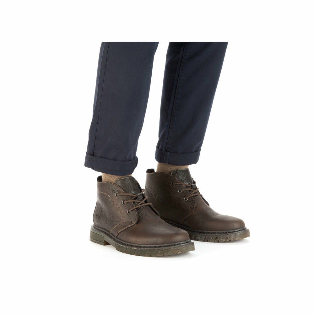 Dunkelbraune Rieker Herren Schnürstiefel 31640-25 mit einer robusten Profilsohle. Schuh am Fuß