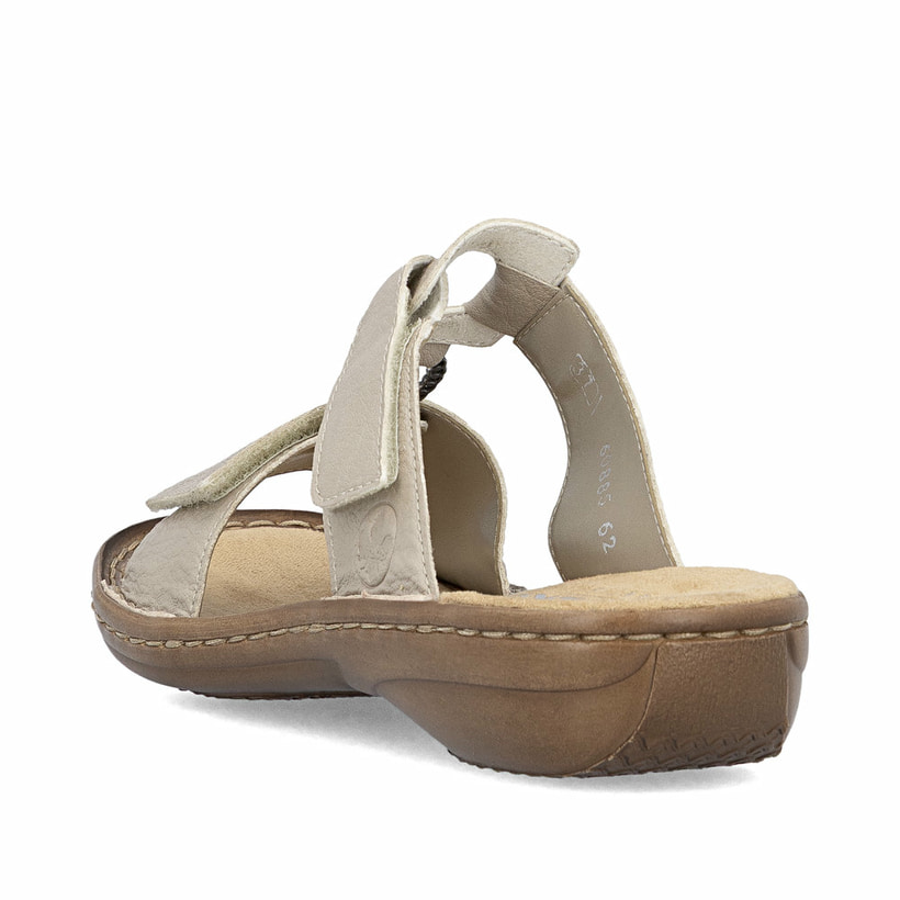 Beige Rieker Damen Pantoletten 60885-62 in Löcheroptik mit einem Klettverschluss. Schuh von hinten.