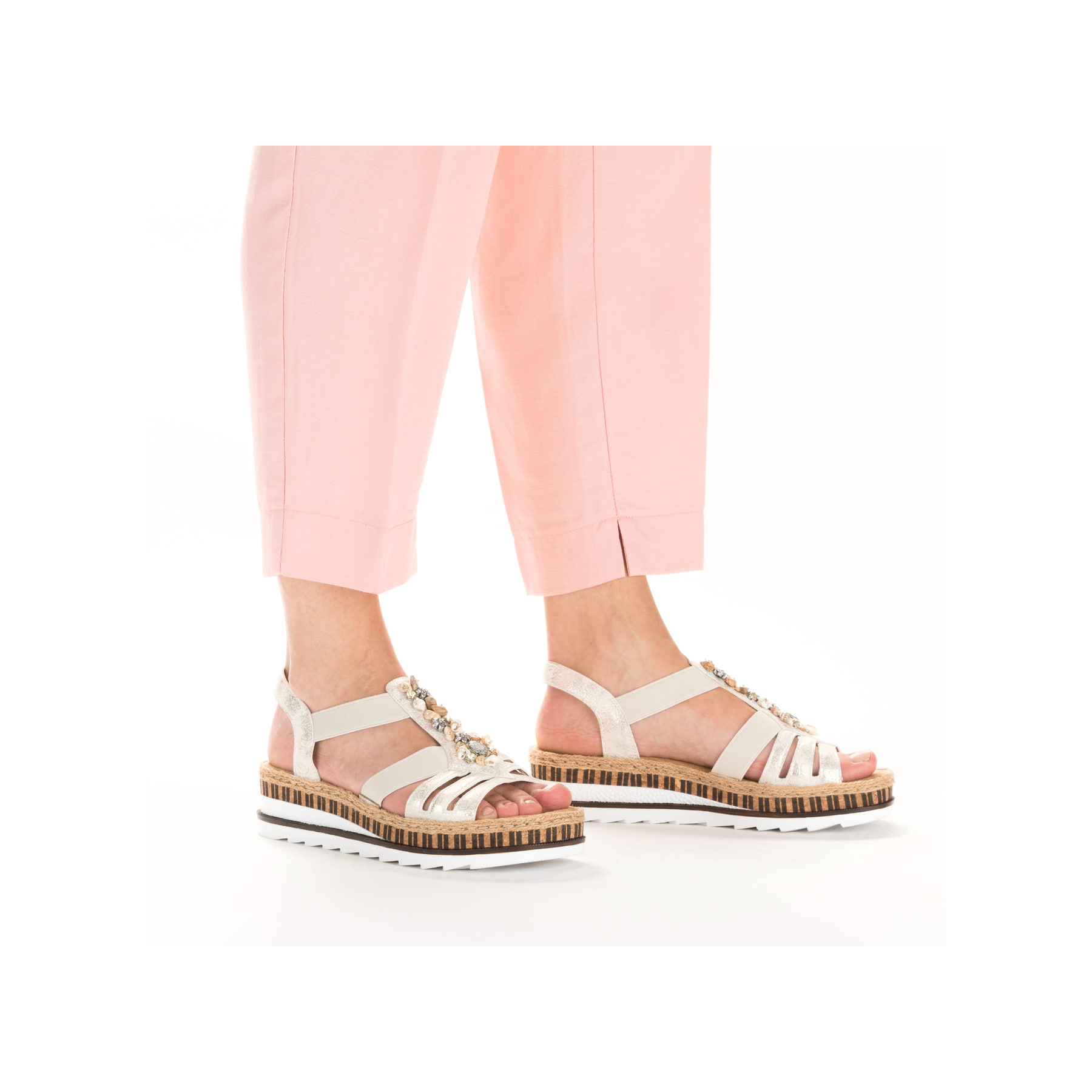 Goldene Rieker Keilsandaletten V7949-90 mit Schmuckelementen sowie Gummizug. Schuh am Fuß.