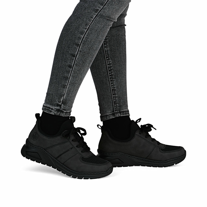 Dunkelgraue Rieker Damen Slipper M4970-45 mit einem Gummizug sowie Extraweite H. Schuh am Fuß.