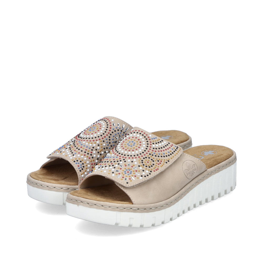 Beige Rieker Damen Pantoletten V1395-62 mit einem Klettverschluss. Schuhpaar seitlich schräg.
