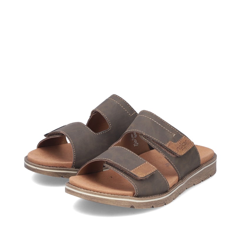 Braune Rieker Herren Pantoletten 24394-25 mit modernen Ziernähten. Schuhpaar seitlich schräg.