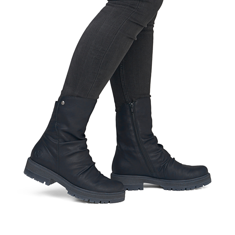 Schwarze Rieker Damen Kurzstiefel 75851-00 mit modischer Faltenoptik. Schuh am Fuß.