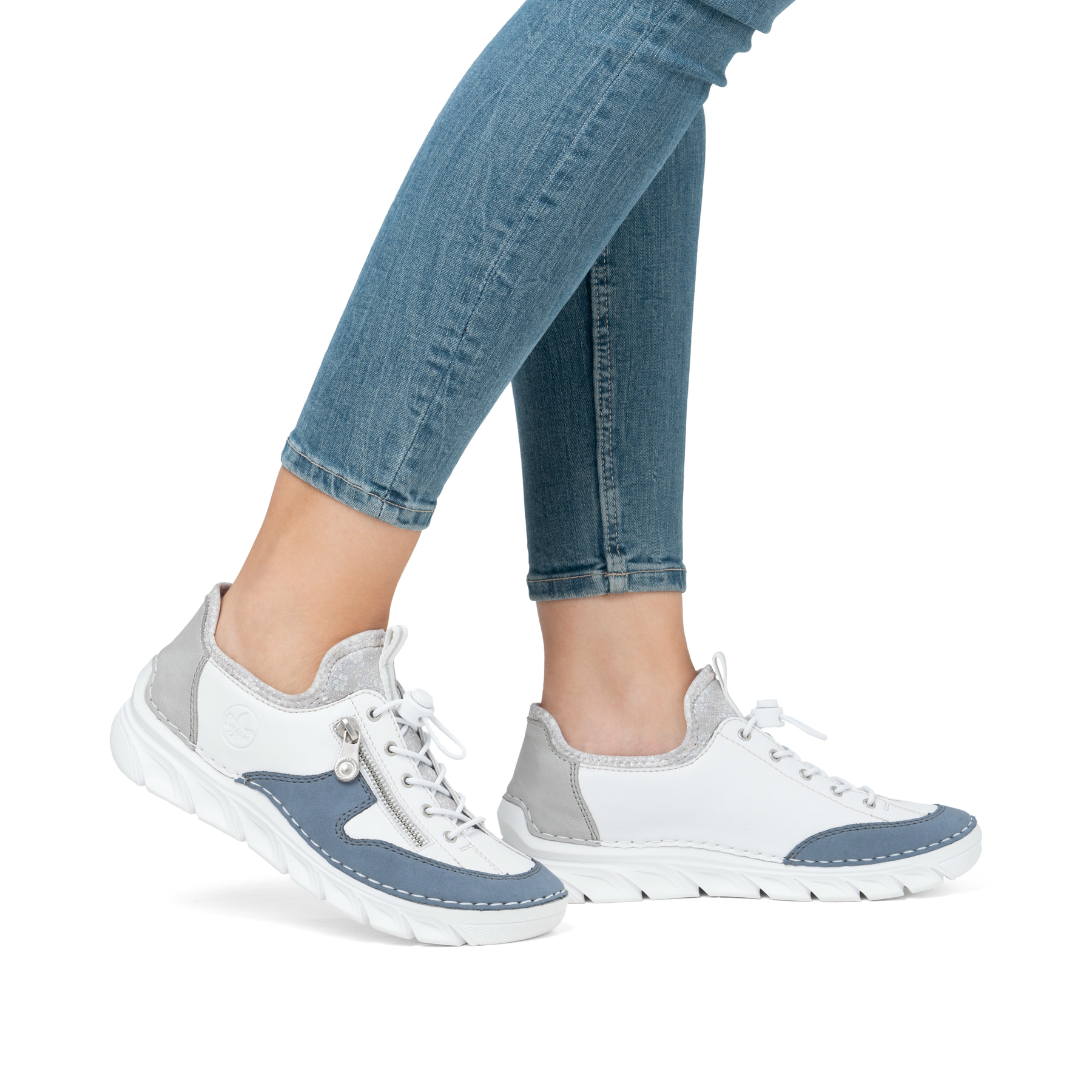 Weiße Rieker Damen Slipper 55064-80 mit Deko-Reißverschluss sowie einem Gummizug. Schuh am Fuß.