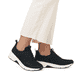Schwarze Rieker Damen Slipper 48157-00 mit Gummischnürung sowie Komfortweite G. Schuh am Fuß.