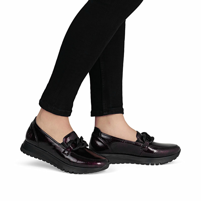 Dunkelrote Rieker Damen Loafer 49051-35 mit Deko-Kette sowie einem Gummizug. Schuh am Fuß.
