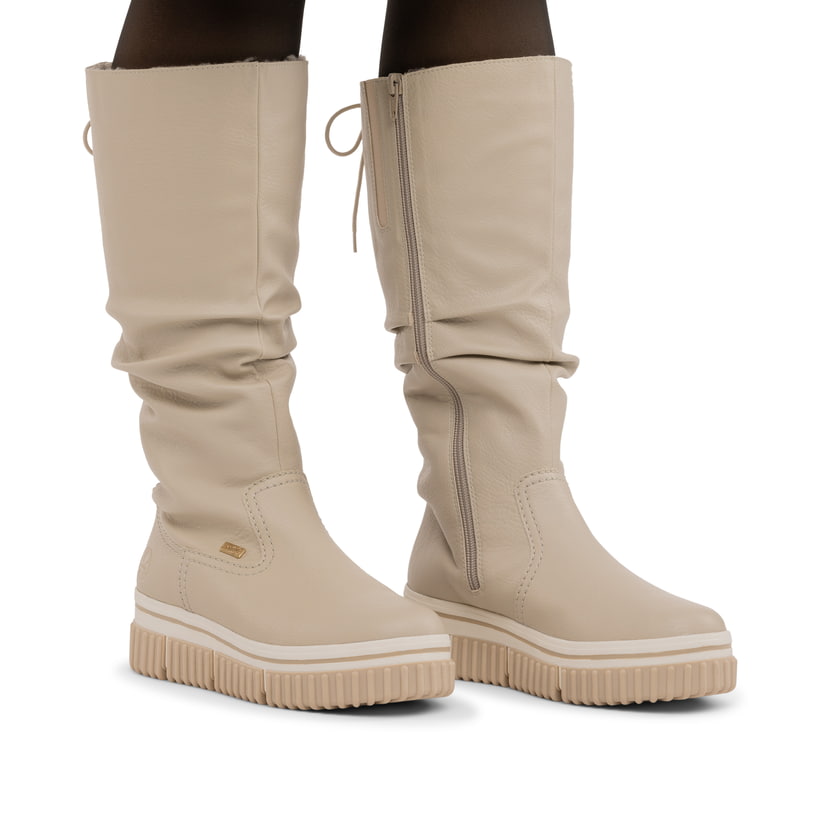 Cremefarbene Rieker Damen Hochschaftstiefel Y6370-60 mit gerafftem Schaft. Schuh am Fuß.