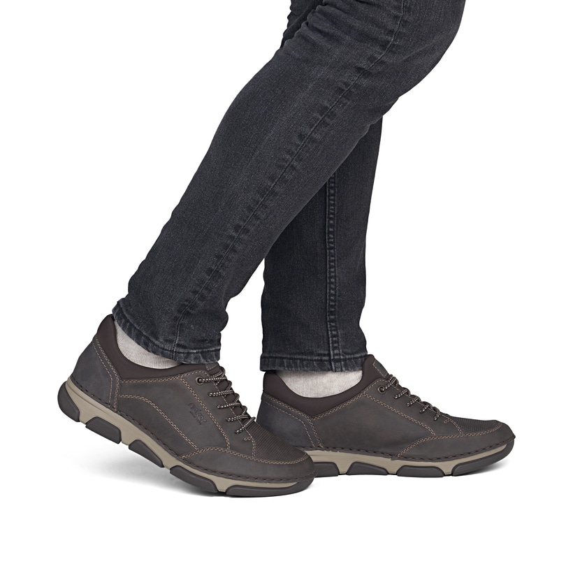Dunkelbraune Rieker Herren Slipper 15950-25 mit Gummizug sowie der Extraweite H. Schuh am Fuß.