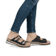 Schwarze Rieker Damen Pantoletten V7955-00 mit trendigen Schnalle. Schuh am Fuß.