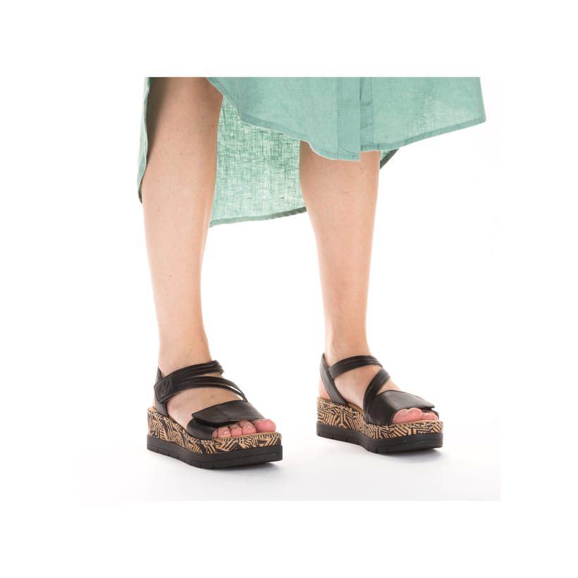 Schwarze Rieker Keilsandaletten V3964-02 mit stilvollem Muster. Schuh am Fuß.