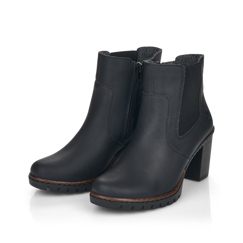 Tiefschwarze Rieker Damen Stiefeletten Y2574-00 mit Reißverschluss sowie Blockabsatz. Schuhpaar schräg.