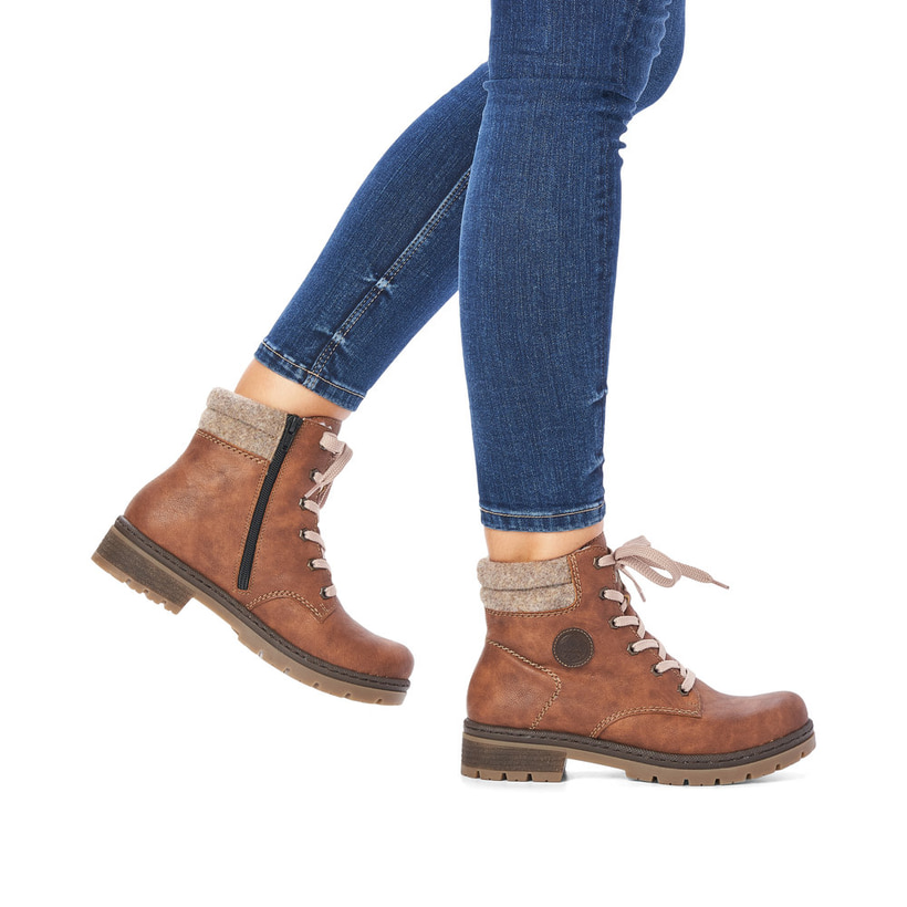 Braune Rieker Damen Schnürstiefel Y7428-22 mit Schaftkragen sowie Reißverschluss. Schuh am Fuß.