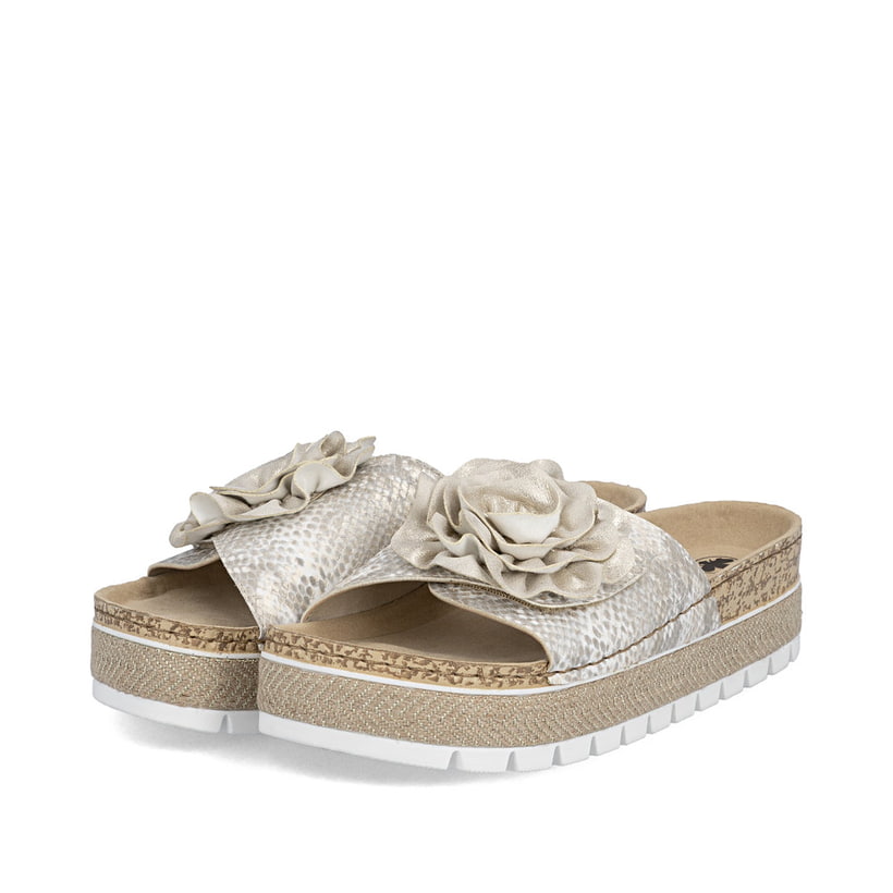 Mules Rieker dorées pour femme 69562-90 avec fleur décorative. Chaussures inclinées sur le côté.