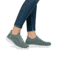 Grüne Rieker Damen Slipper M5074-52 mit einem Gummizug sowie ultraleichter Sohle. Schuh am Fuß.