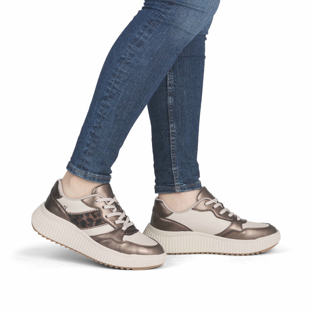 Beige Rieker Damen Sneaker Low W1702-60 aus Glattleder mit Leo-Print. Schuh am Fuß.
