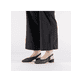 Schwarze Rieker Slingpumps 47060-01 mit eleganten Zierlochungen sowie Schnallen. Schuh am Fuß.
