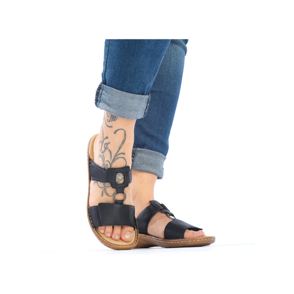 Schwarze Rieker Damen Pantoletten 60885-00 mit Schmuckelementen. Schuh am Fuß.