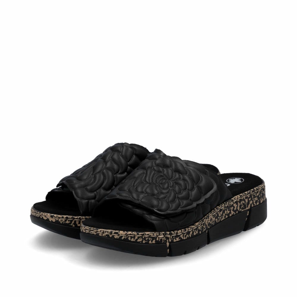 Schwarze Rieker Damen Pantoletten V2351-00 mit floralem Muster. Schuhpaar seitlich schräg.