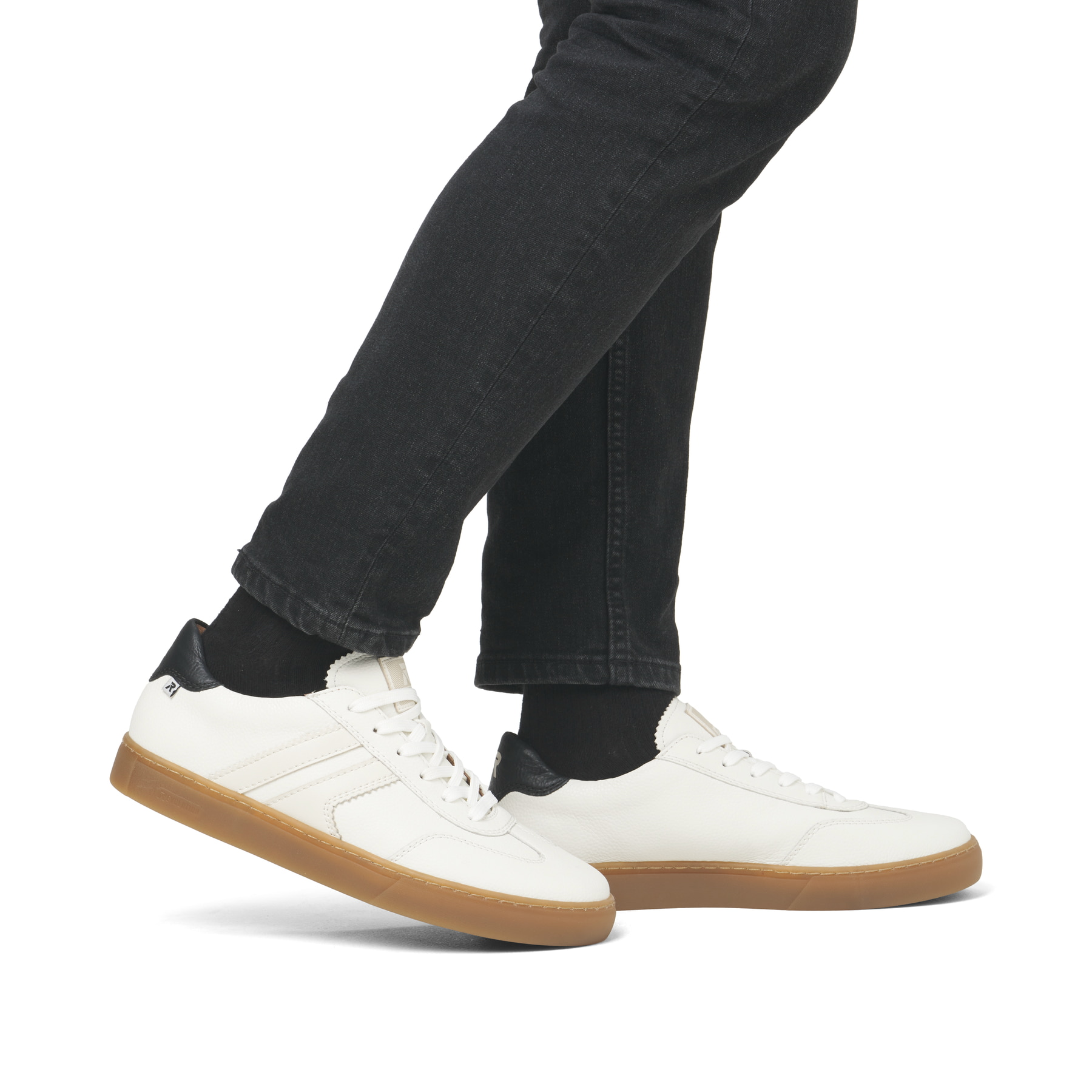 Weiße Rieker Herren Sneaker Low U0707-80 im Retro-Look mit weißen Streifen an der Seite sowie einer Schnürung. Schuh am Fuß.