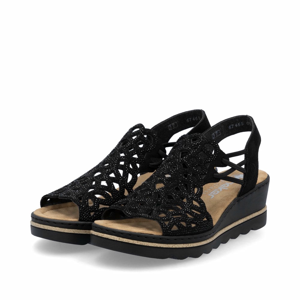Schwarze Rieker Keilsandaletten 67465-00 mit Strasssteinen sowie einem Gummizug. Schuhpaar seitlich schräg.