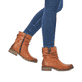 
Karamellbraune Rieker Damen Kurzstiefel Z4180-22 mit einer schockabsorbierenden Sohle. Schuh am Fuß