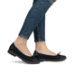 Schwarze Rieker Ballerinas 45358-00 mit dekorativer Schleife. Schuh am Fuß.