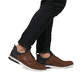 Braune Rieker Herren Slipper 14450-22 mit Gummizug sowie der Komfortweite G 1/2. Schuh am Fuß.