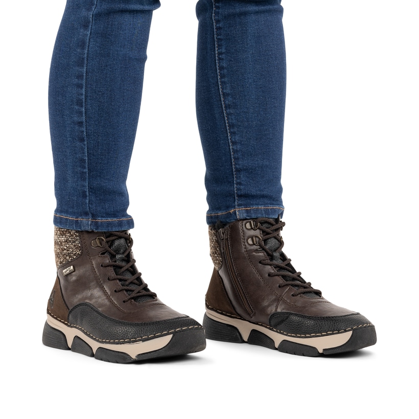 Dunkelbraun-beige Rieker Damen Schnürstiefel 45956-25 mit Strick-Kragen. Schuh am Fuß.