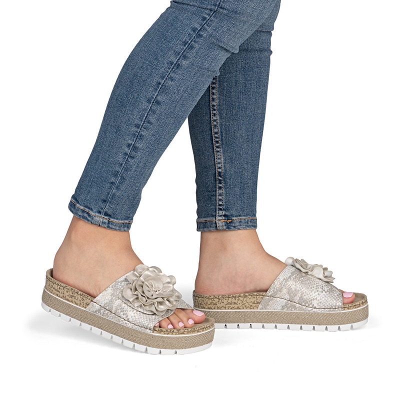 Mules Rieker dorées pour femme 69562-90 avec fleur décorative. Chaussure au pied.