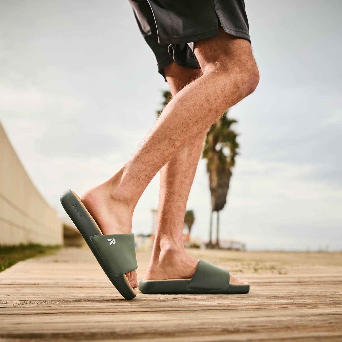 Grüne Rieker Herren Pantoletten U3250-54 mit flexibler und ultraleichter Sohle. Schuh am Model.