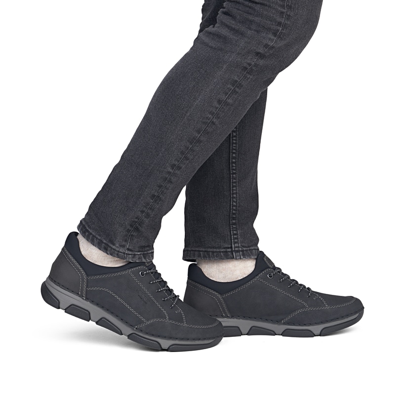 Schwarze Rieker Herren Slipper 15950-00 mit einem Gummizug sowie Extraweite H. Schuh am Fuß.