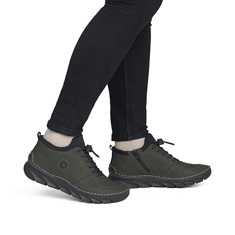 Dunkelgrün-schwarze Rieker Damen Kurzstiefel 55071-54 mit einem Reißverschluss. Schuh am Fuß.