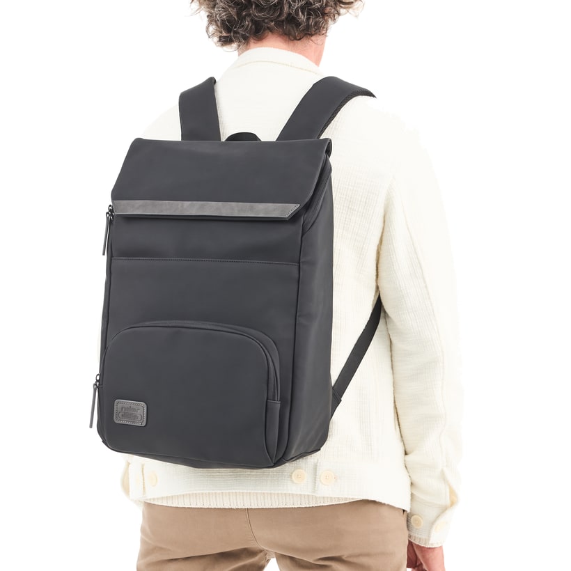 Sac à dos Rieker H5102-01 noir avec rabat à fermeture magnétique, compartiment rembourré pour ordinateur portable et bretelles ajustable. Porté.